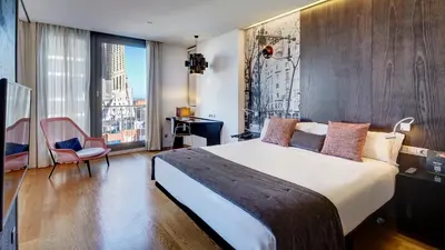 a bedroom with a large bed and a large window at Sercotel Hotel Rosellon in Barcelona