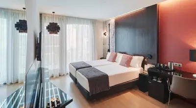 a hotel room with a bed and a television at Sercotel Hotel Rosellon in Barcelona