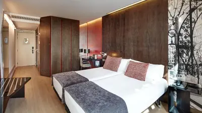 a bedroom with a large white bed and a desk at Sercotel Hotel Rosellon in Barcelona