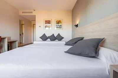 a bedroom with two large white beds with pillows at Hotel Air Penedès in Vilafranca del Penedès
