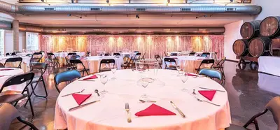 a large room with tables and chairs and wine barrels at Hotel Air Penedès in Vilafranca del Penedès