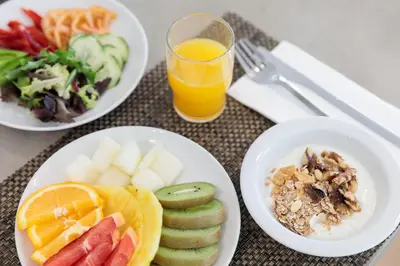a table with three plates of food and a glass of orange juice at Hotel Best 4 Barcelona in Barcelona