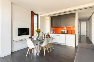 a kitchen with a table and chairs and a kitchen with orange at Cosmo Apartments Sants in Barcelona