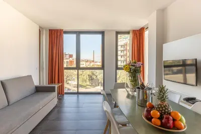 a living room with a couch and a table with fruit on it at Cosmo Apartments Sants in Barcelona