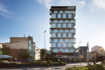 a tall building with a sign on the side of it at Cosmo Apartments Sants in Barcelona