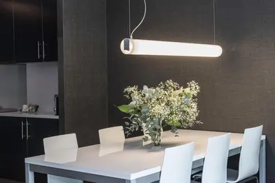 a dining room table with white chairs and a vase of flowers at Casp 74 Apartments in Barcelona