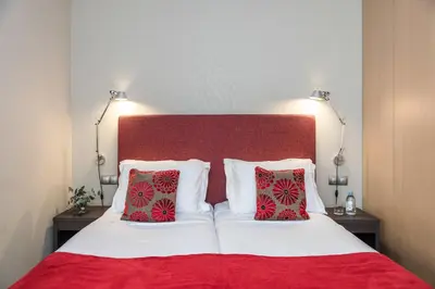 a bedroom with a red and white bed with two pillows at Casp 74 Apartments in Barcelona