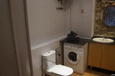 a bathroom with a washing machine and a sink at Urbi Apartments in Manresa