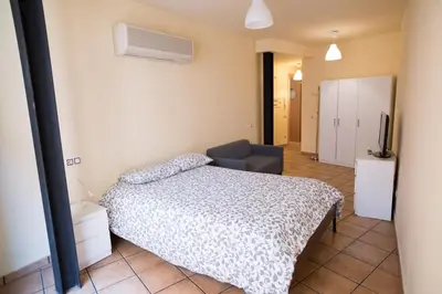 a bedroom with a bed and a couch and a television at Urbi Apartments in Manresa