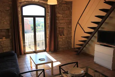a living room with a table and chairs and a window at Urbi Apartments in Manresa
