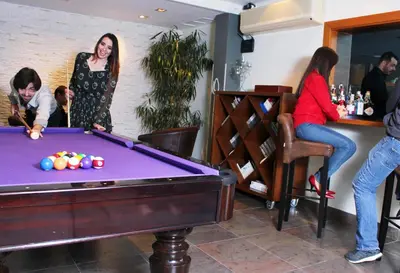 a group of people standing around a pool table at Montaltmar in Sant Vicenç de Montalt