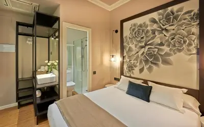 a bedroom with a bed with a painting on the wall at Hostal Central Barcelona in Barcelona