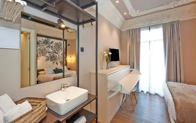 a bathroom with a sink and a mirror and a bed at Hostal Central Barcelona in Barcelona