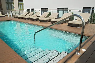 a large swimming pool with lounge chairs in a building at Grupotel Gran Via 678 in Barcelona