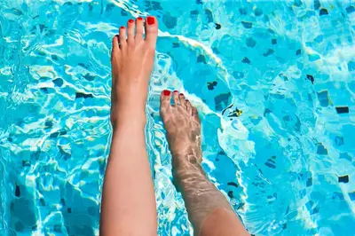 a woman with her feet in a swimming pool at Grupotel Gran Via 678 in Barcelona