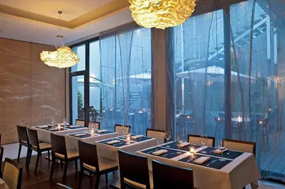 a group of tables in a room with large windows at Grupotel Gran Via 678 in Barcelona