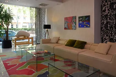 a living room with a couch and a glass table at Grupotel Gran Via 678 in Barcelona