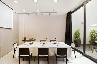 a dining room with a white table and chairs at Grupotel Gran Via 678 in Barcelona