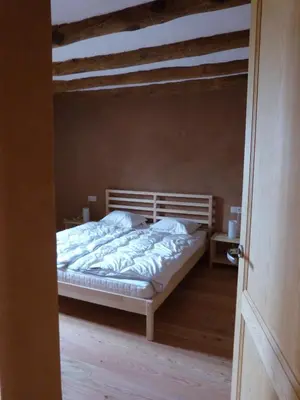 a bedroom with a bed and a wooden door at Can Gramunt in La Torre de Claramunt