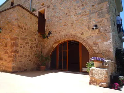 a brick building with a door and a window at Can Gramunt in La Torre de Claramunt