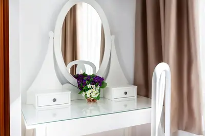 a dressing table with a mirror and a vase of flowers at Hostal Ramos in Barcelona
