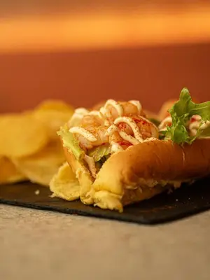 a sandwich sitting on top of a black plate at Alenti Sitges Hotel in Sitges