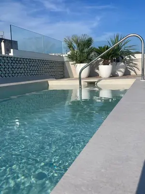 a swimming pool with a fountain in the middle of a building at Alenti Sitges Hotel in Sitges