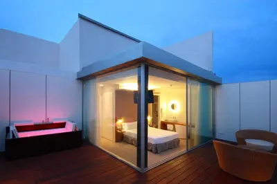 a room with a bedroom with a bed and a room with avisor at Alenti Sitges Hotel in Sitges