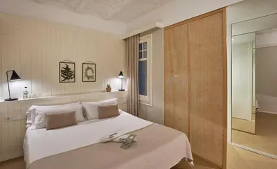 a bedroom with a large white bed and a walk in shower at The Moods Catedral Hostal Boutique in Barcelona