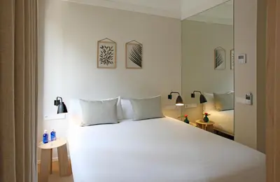 a bedroom with a large white bed with two lamps at The Moods Catedral Hostal Boutique in Barcelona