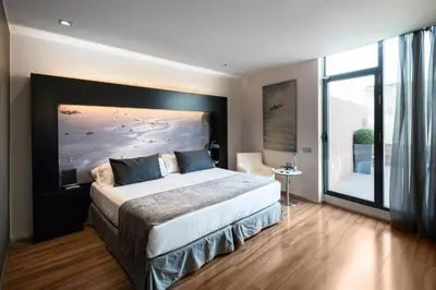 a bedroom with a large bed and a large window at Catalonia Catedral in Barcelona