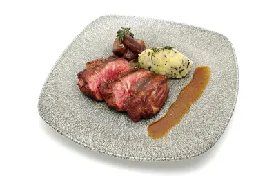 a plate of food with meat and potatoes and sauce at Catalonia Catedral in Barcelona