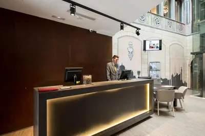 a man standing at a bar in a room at Catalonia Catedral in Barcelona