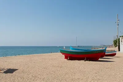 three boats sitting on a beach near the water at Hostal Solimar in Badalona