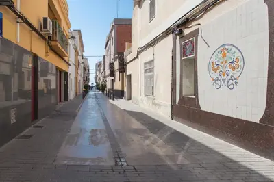 an empty street in an alley with a mural on the wall at Hostal Solimar in Badalona
