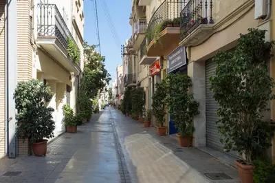 an empty street with potted plants on the sides of buildings at Hostal Solimar in Badalona