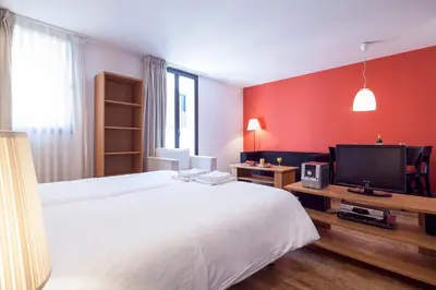 a bedroom with a white bed and a tv at Inside Barcelona Apartments Sants in Barcelona