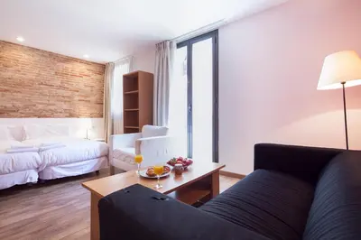 a living room with a couch and a bed at Inside Barcelona Apartments Sants in Barcelona