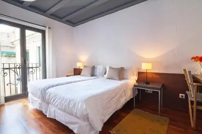 a white bed in a room with a large window at Inside Barcelona Apartments Esparteria in Barcelona