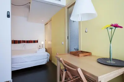 a room with a table and a bed with a vase on it at Inside Barcelona Apartments Esparteria in Barcelona