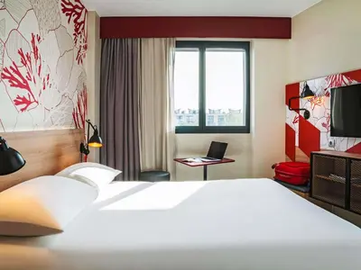a hotel room with a large white bed and a window at ibis Styles Barcelona City Bogatell in Barcelona