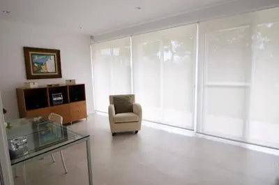 a living room with a chair and a glass table at Luxury Beach House in Sitges
