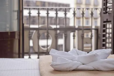a pile of towels sitting on top of a bed at Barcelona City Hotel in Barcelona