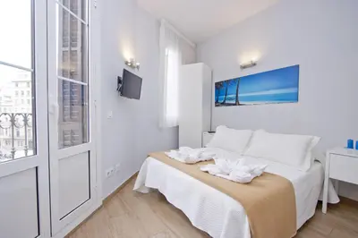 a white bedroom with a bed and a window at Barcelona City Hotel in Barcelona