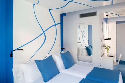 a bedroom with a white bed with blue pillows at Allegro Barcelona in Barcelona