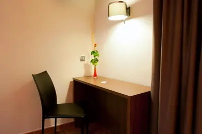 a desk with a chair and a plant in a room at Bed and Breakfast El Pekinaire in Calella