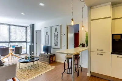 a living room with a table and a kitchen at Sweett - Raul in Barcelona