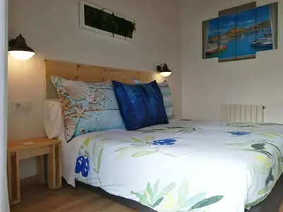 a bedroom with a bed and a wooden headboard at Vila De Premiá in Premiá de Mar