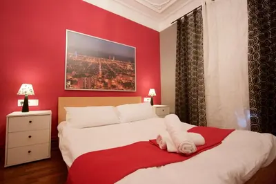 a bedroom with a bed with a red wall at Charm Rambla Catalunya in Barcelona
