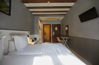 a bedroom with a large white bed and a television at Hostemplo Sagrada Familia in Barcelona